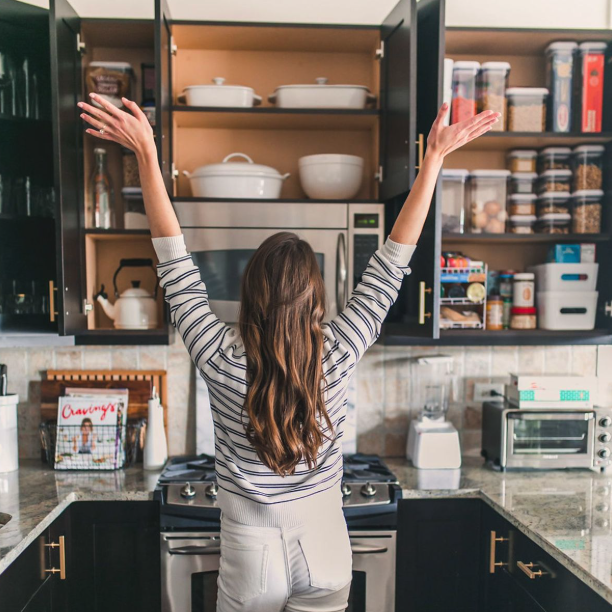 Mujer organizando su hogar con cestas y etiquetas en estanterías
